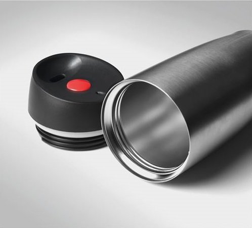 Close-up of red push button on black travel cup lid